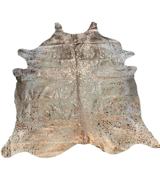 A Champagne Devore Rosegold Acid Washed Brazilian cowhide rug with a patterned texture and a mix of beige, gray, and rose gold colors.